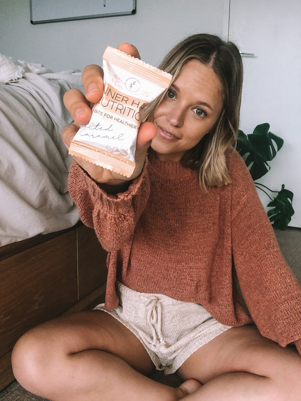 Arna Stevens wellness blog holding salted caramel inner hair nutrition bite towards camera